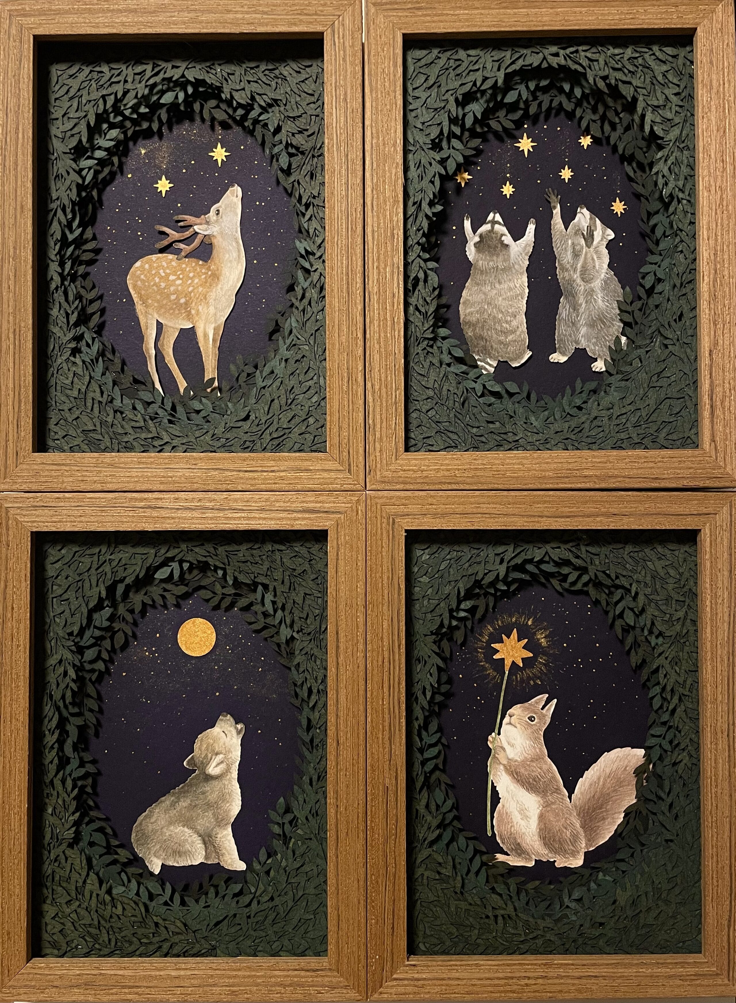 a series of four framed paper collages of animals and foliage