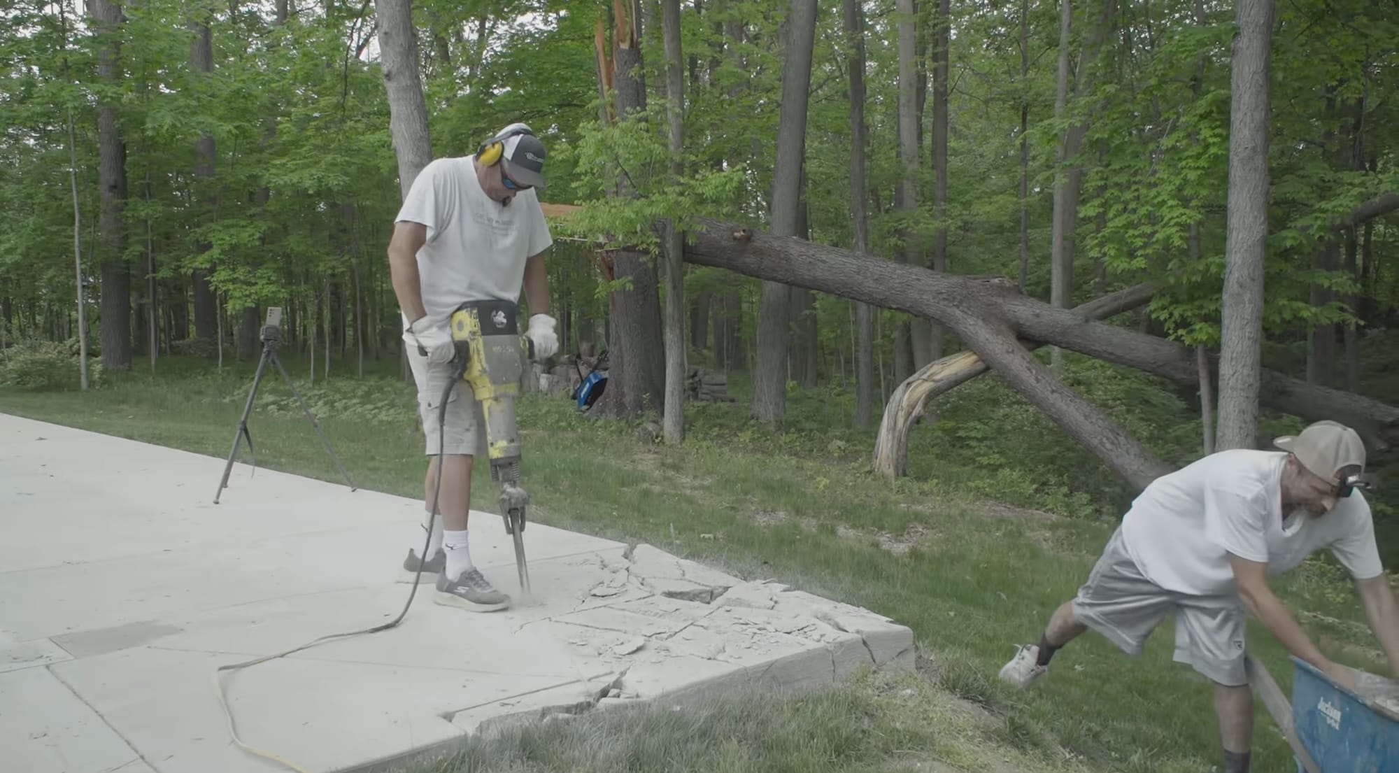 a still from the movie 'The History of Concrete' featuring two men jackhammering a concrete slab