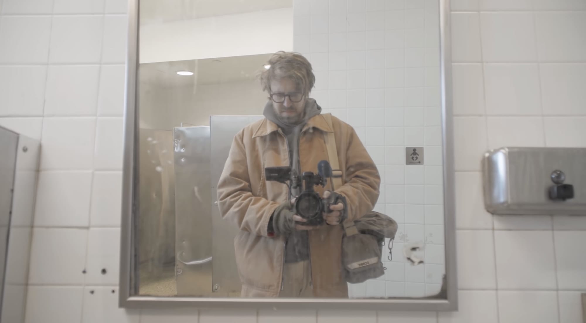 a still from the movie 'The History of Concrete' featuring a self-portrait of filmmaker John Wilson taking a selfie in a mirror