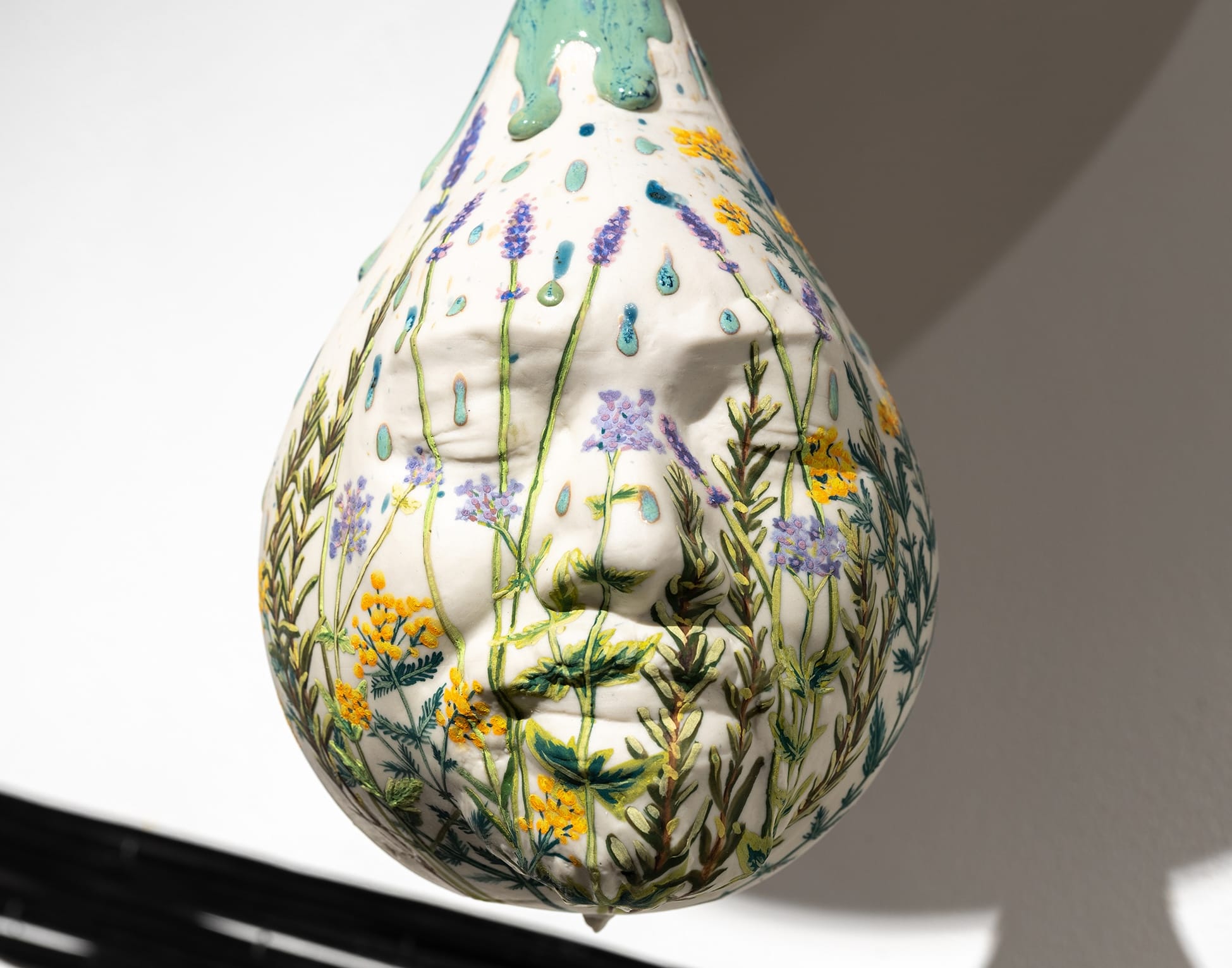 a ceramic punching bag sculpture with a face and flowers on the bag