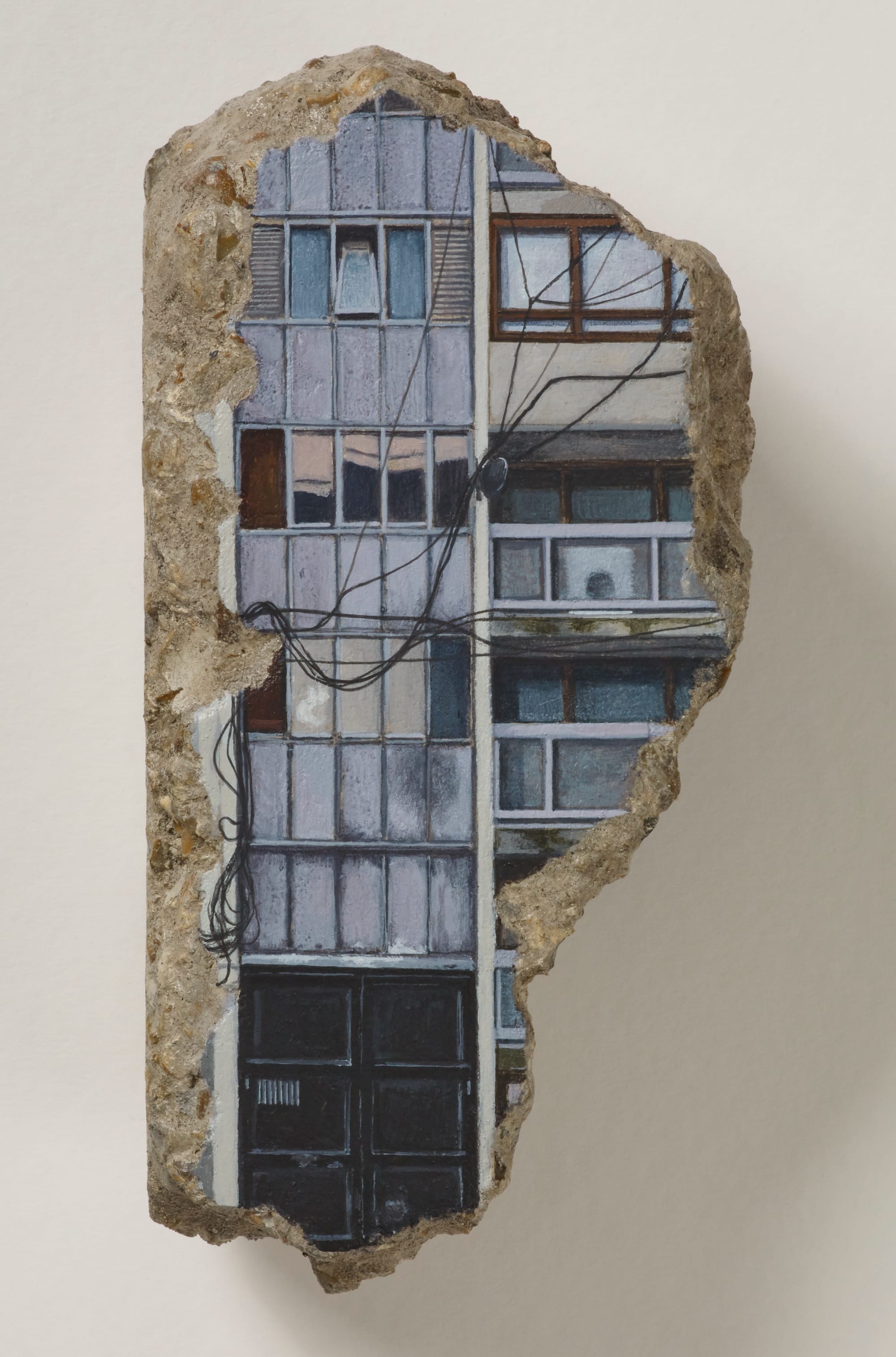 a concrete fragment with a painting of a building facade with wires