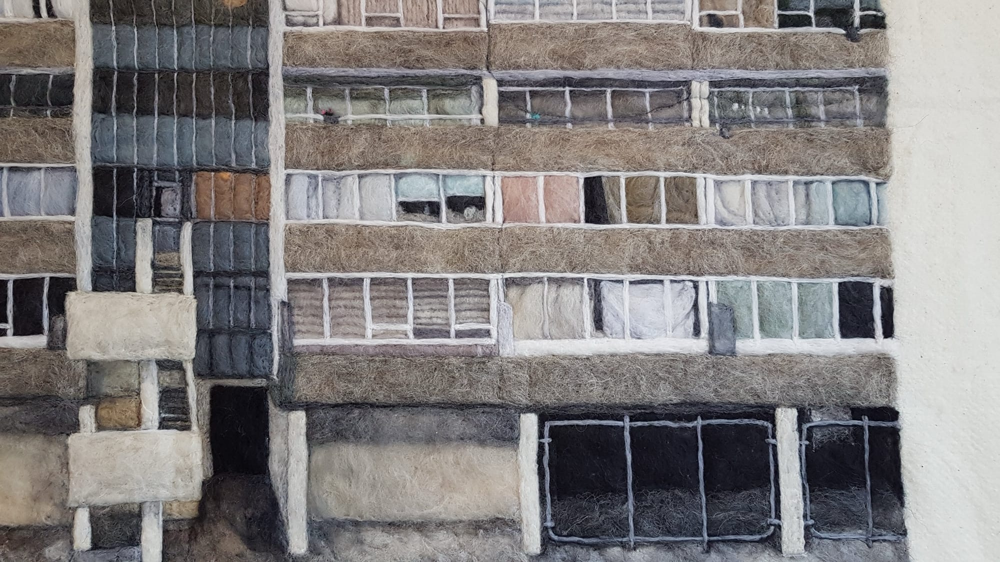 a detail of a textile piece depicting public housing