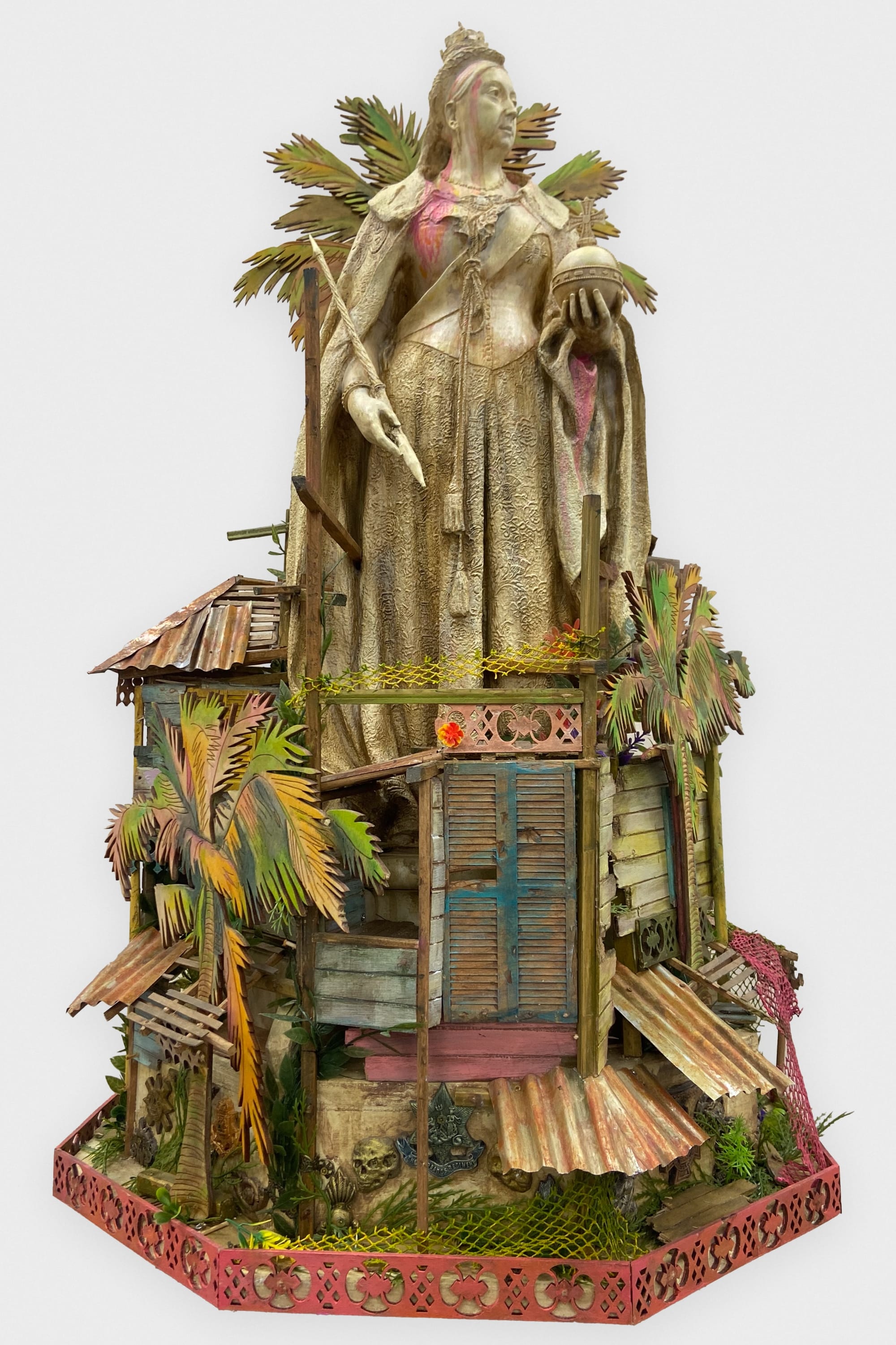 a mixed-media sculpture by Hew Locke of a queen figure standing atop vernacular buildings