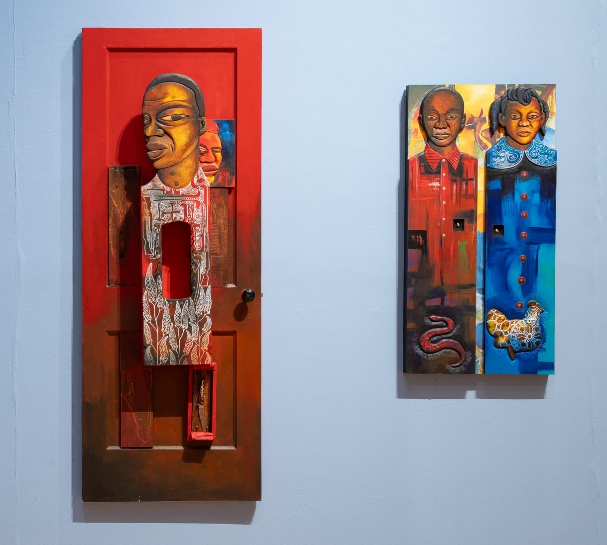 two vibrant carved wall works by Daniel Minter featuring vertical portraits on wood
