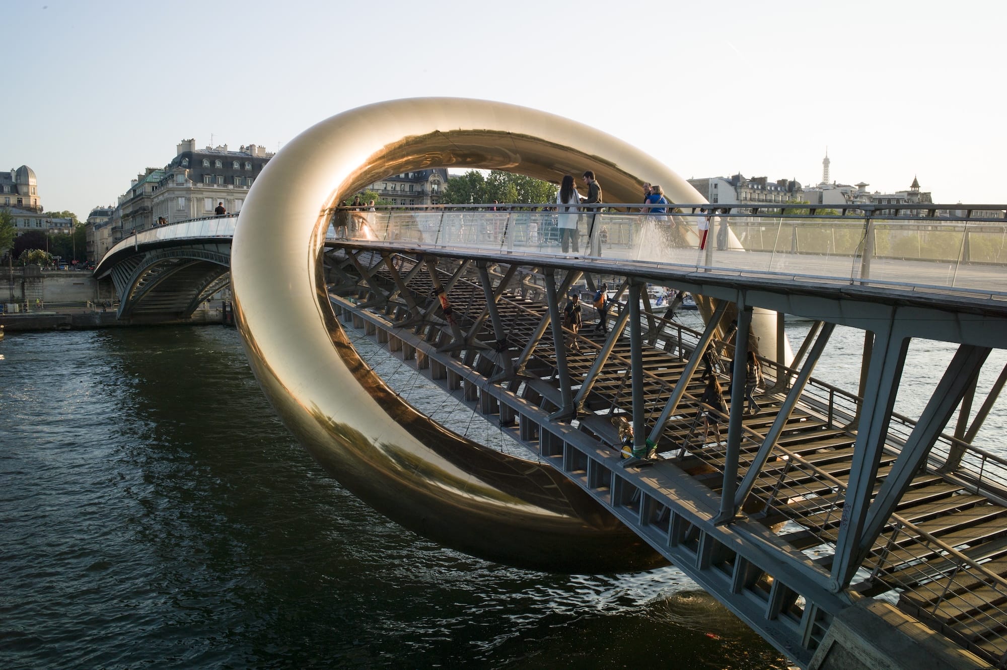 a giant inflatable sculpture of a gold ring encompassing a bridge