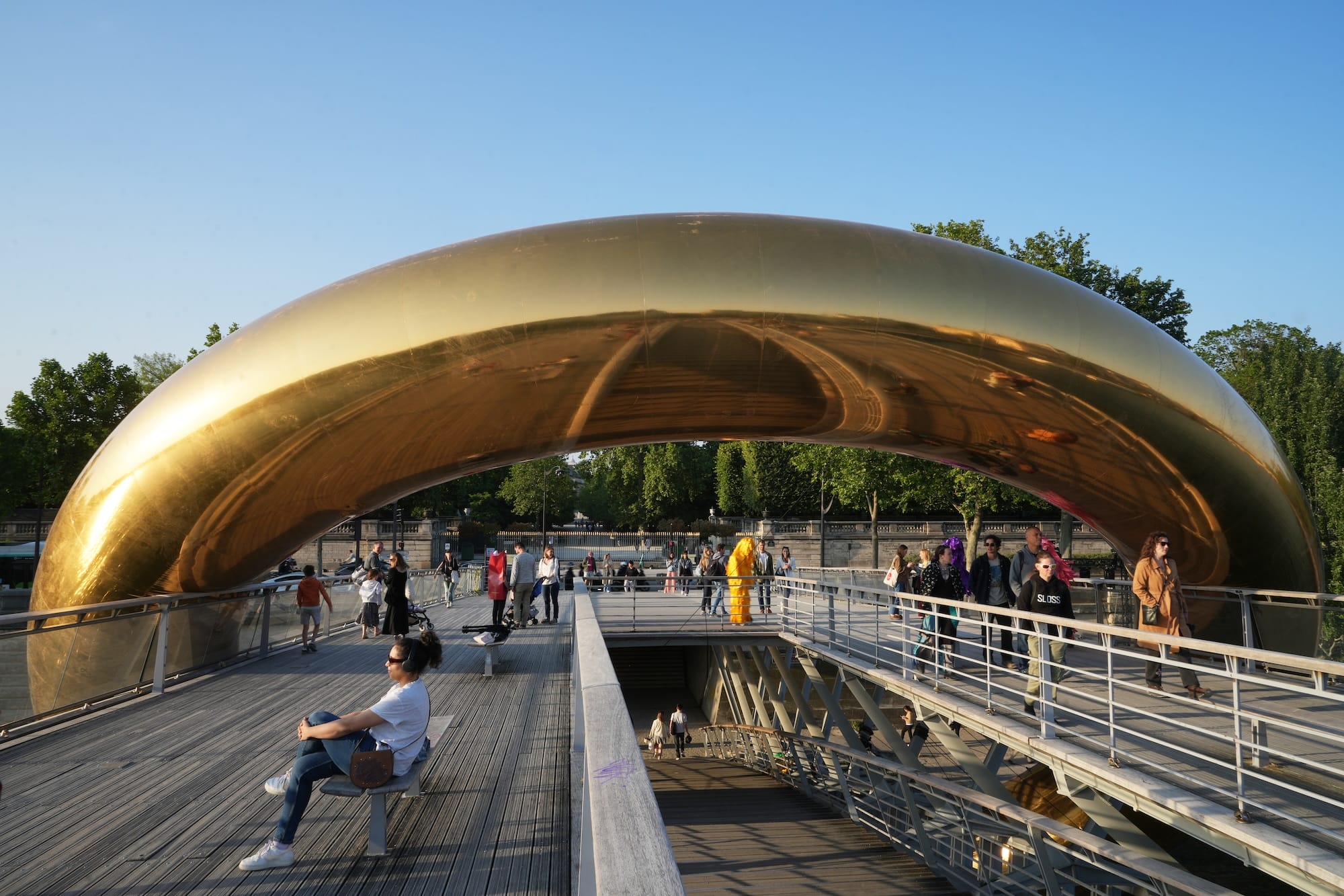 a giant inflatable sculpture of a gold ring encompassing a bridge