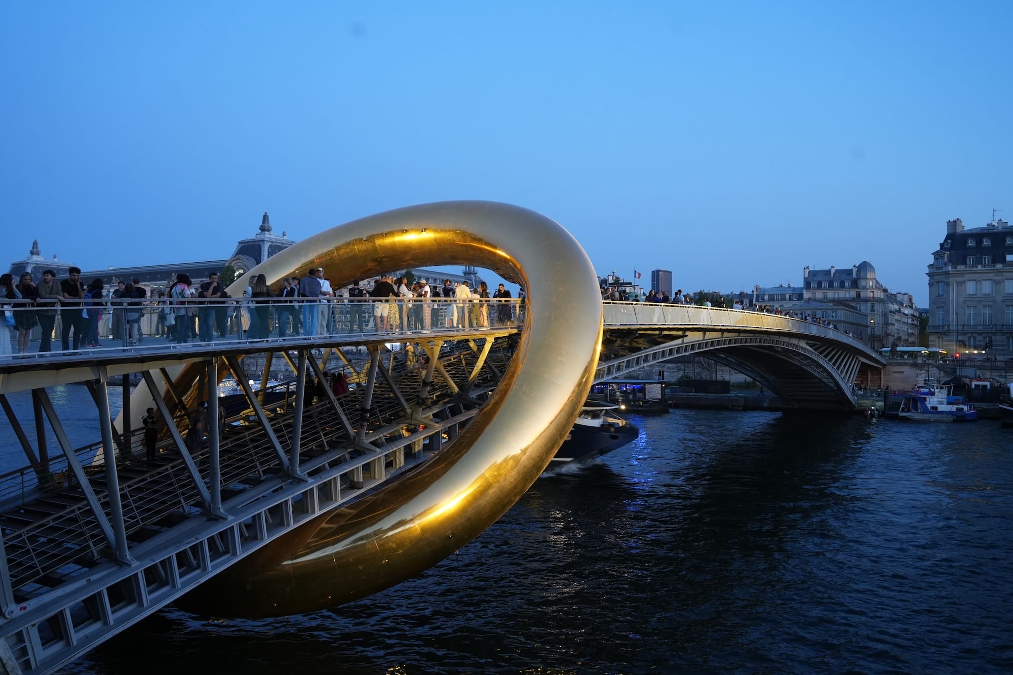 a giant inflatable sculpture of a gold ring encompassing a bridge