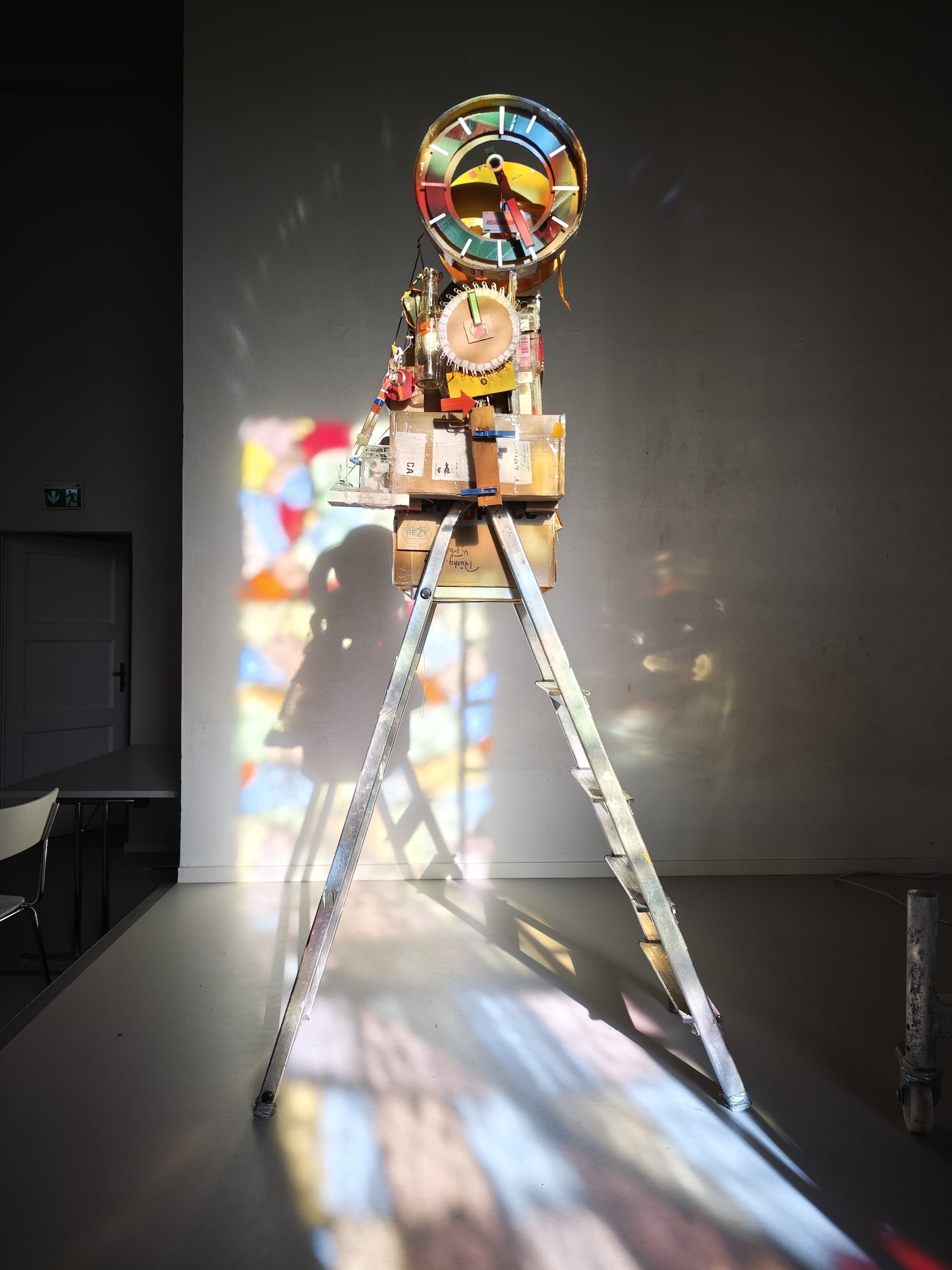 a sculptural, functional clock made from foraged trash, illuminated by a stained glass window
