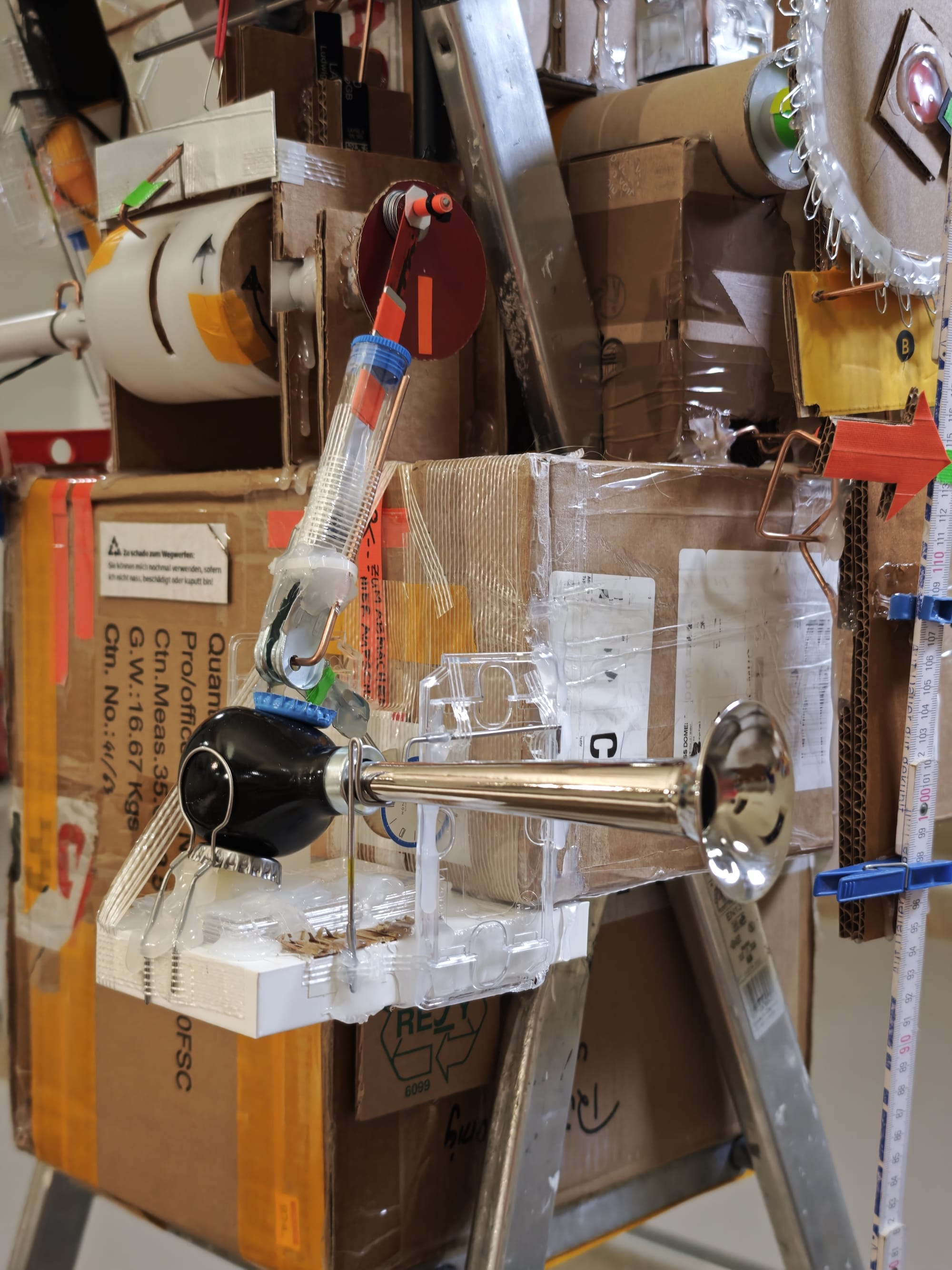 a detailed view of a sculptural, functional clock made from foraged trash