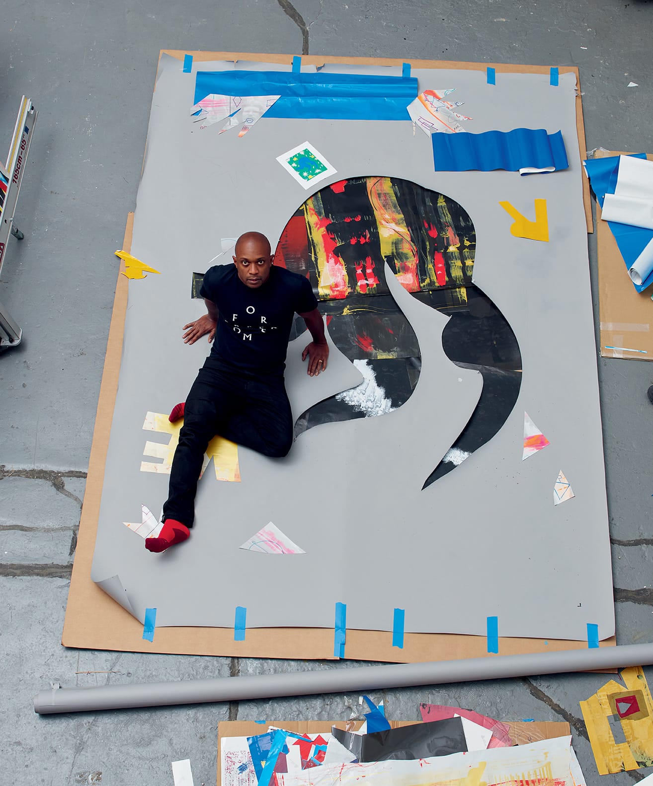 hank willis thomas sitting on a work in his studio