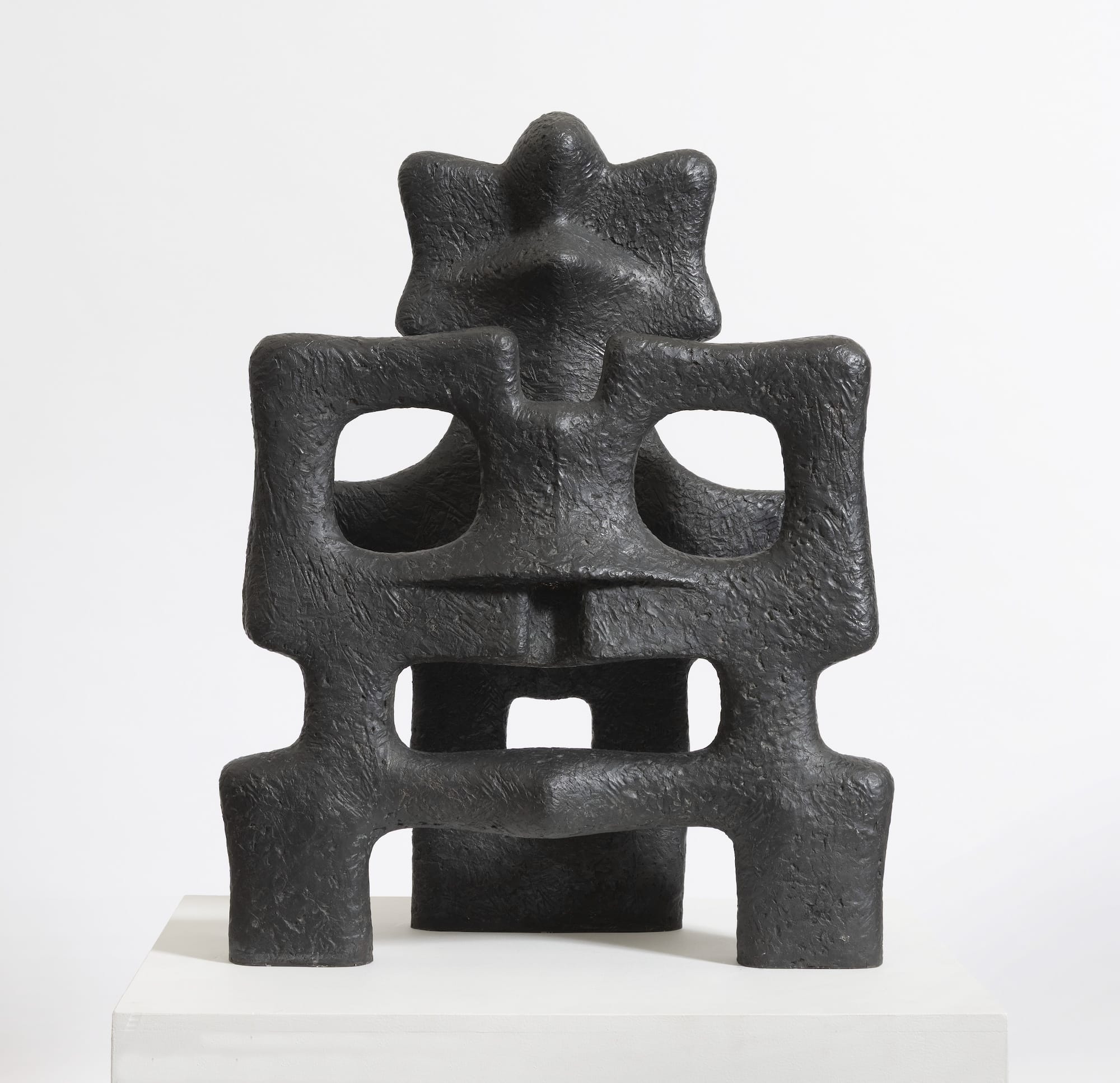 an abstract bronze sculpture that loosely resembles a masked face
