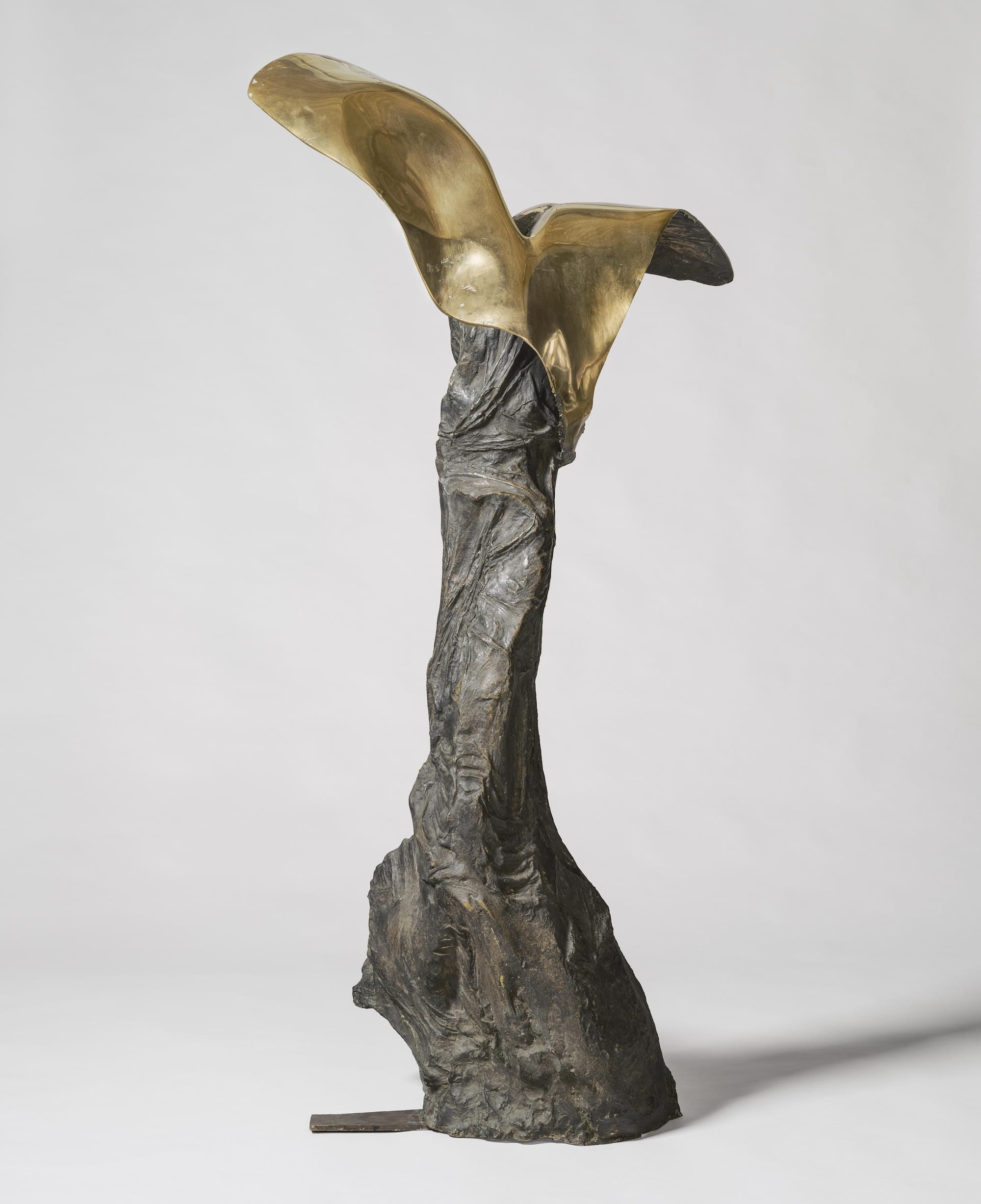 an abstract bronze sculpture that is vaguely figure-like with two wing-like features on top