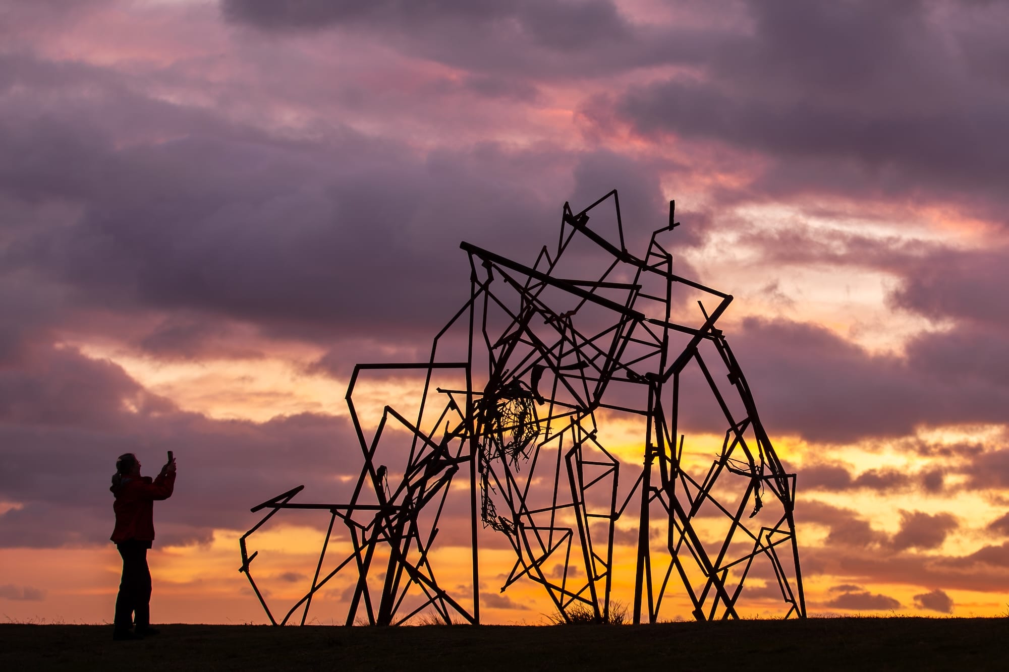 an abstract sculpture at Bondi Beach, NSW, Australia, photographed in silhouette against the sunset