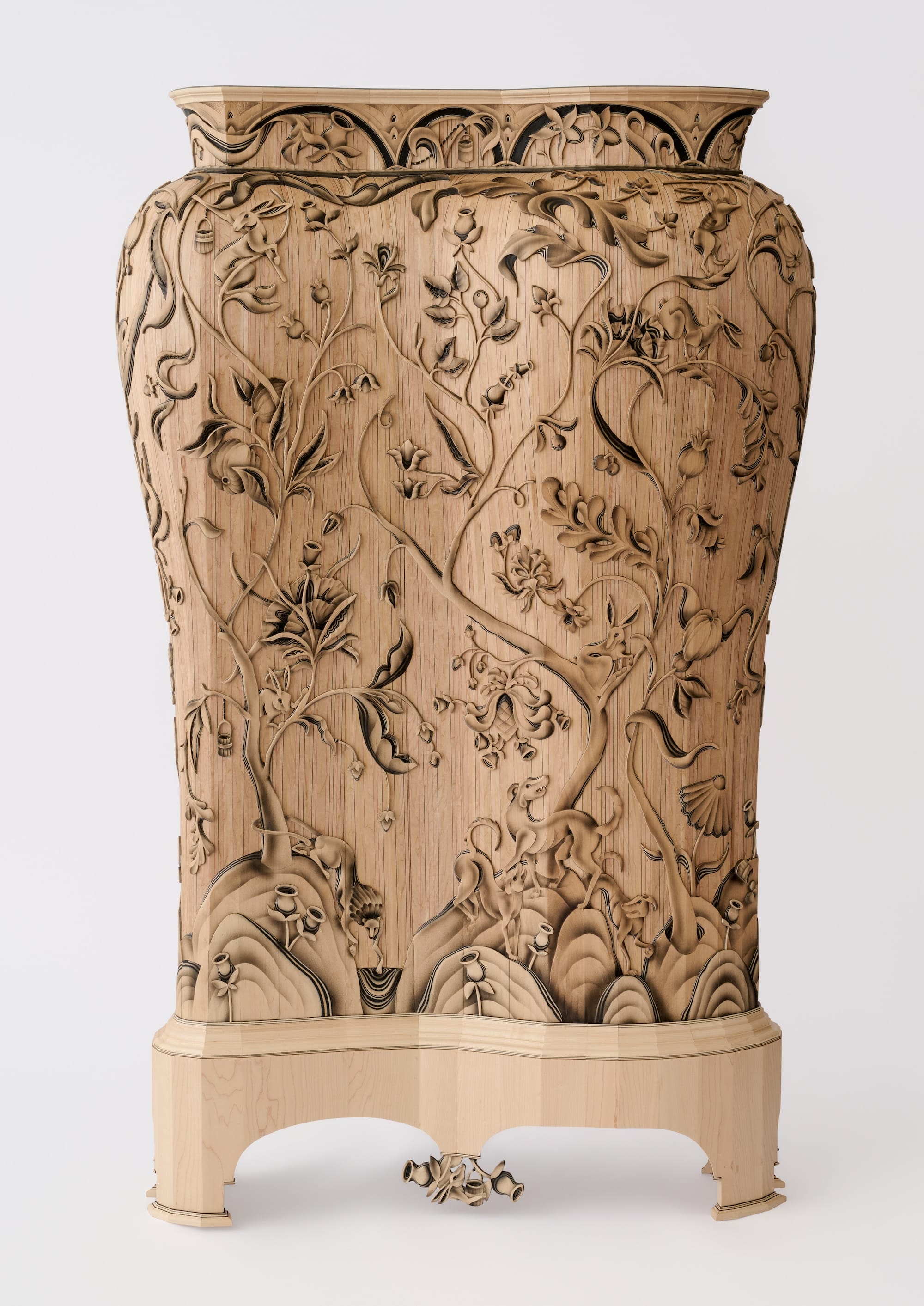 a large wooden cabinet that resembles a giant vessel, with crewel-inspired wood carving on the exterior featuring plants and animals