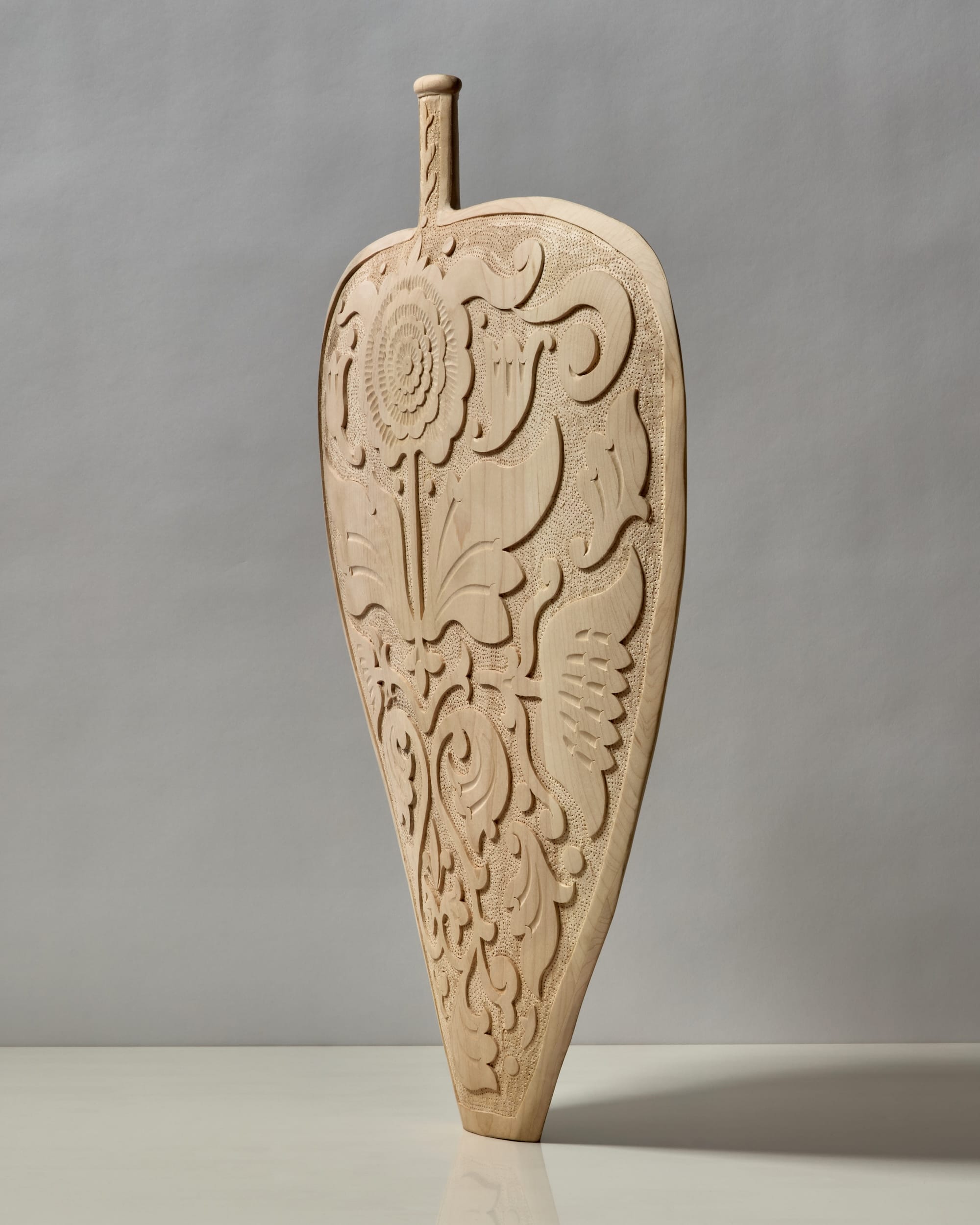 a hand-carved wooden vessel with an assymetrical, tiny neck