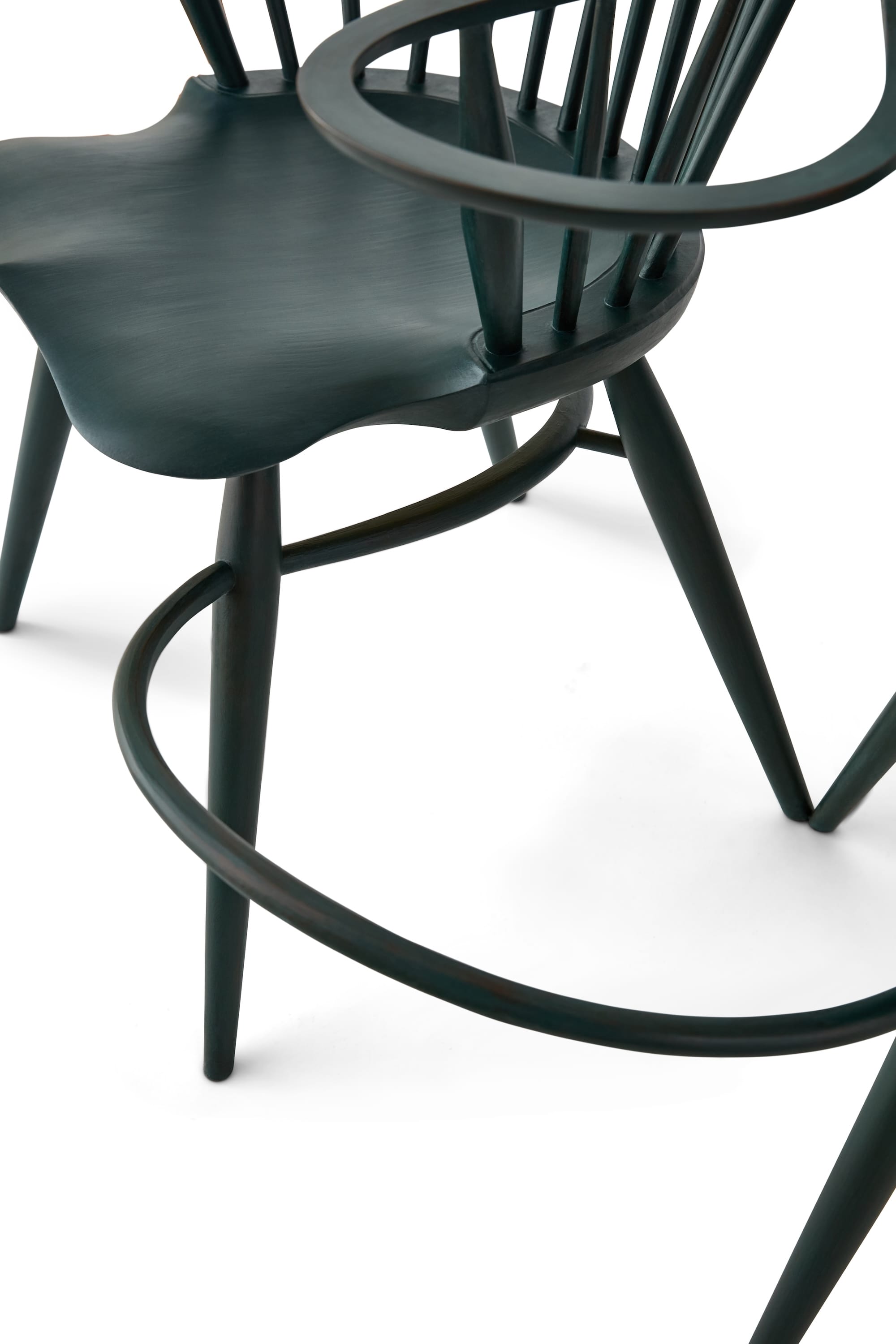 a detail of two handmade spindle-back chairs that are connected by their supports and arms