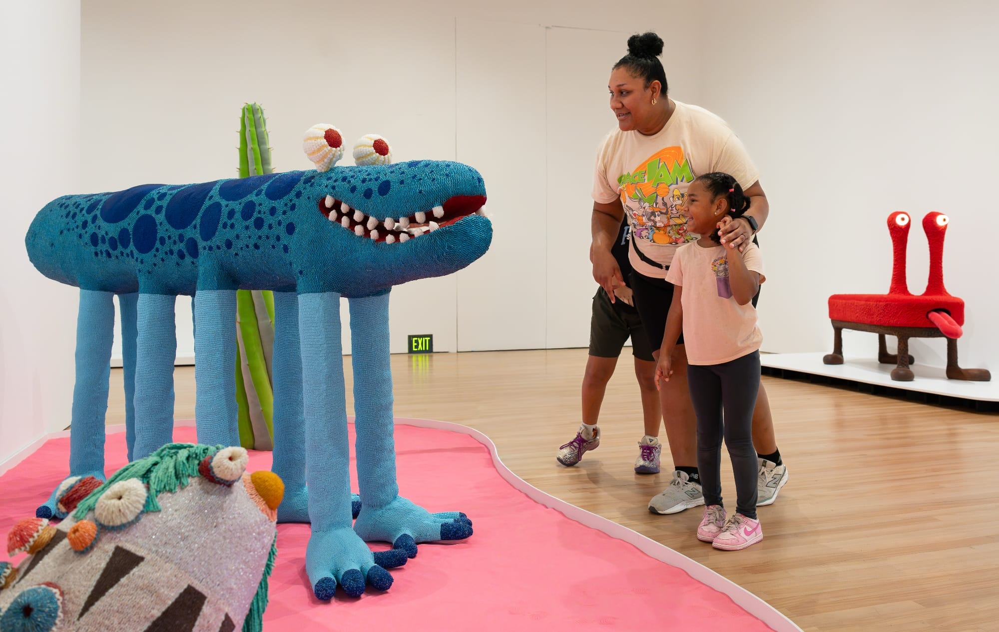 a mother and daughter look at fantastical creatures by the haas brothers