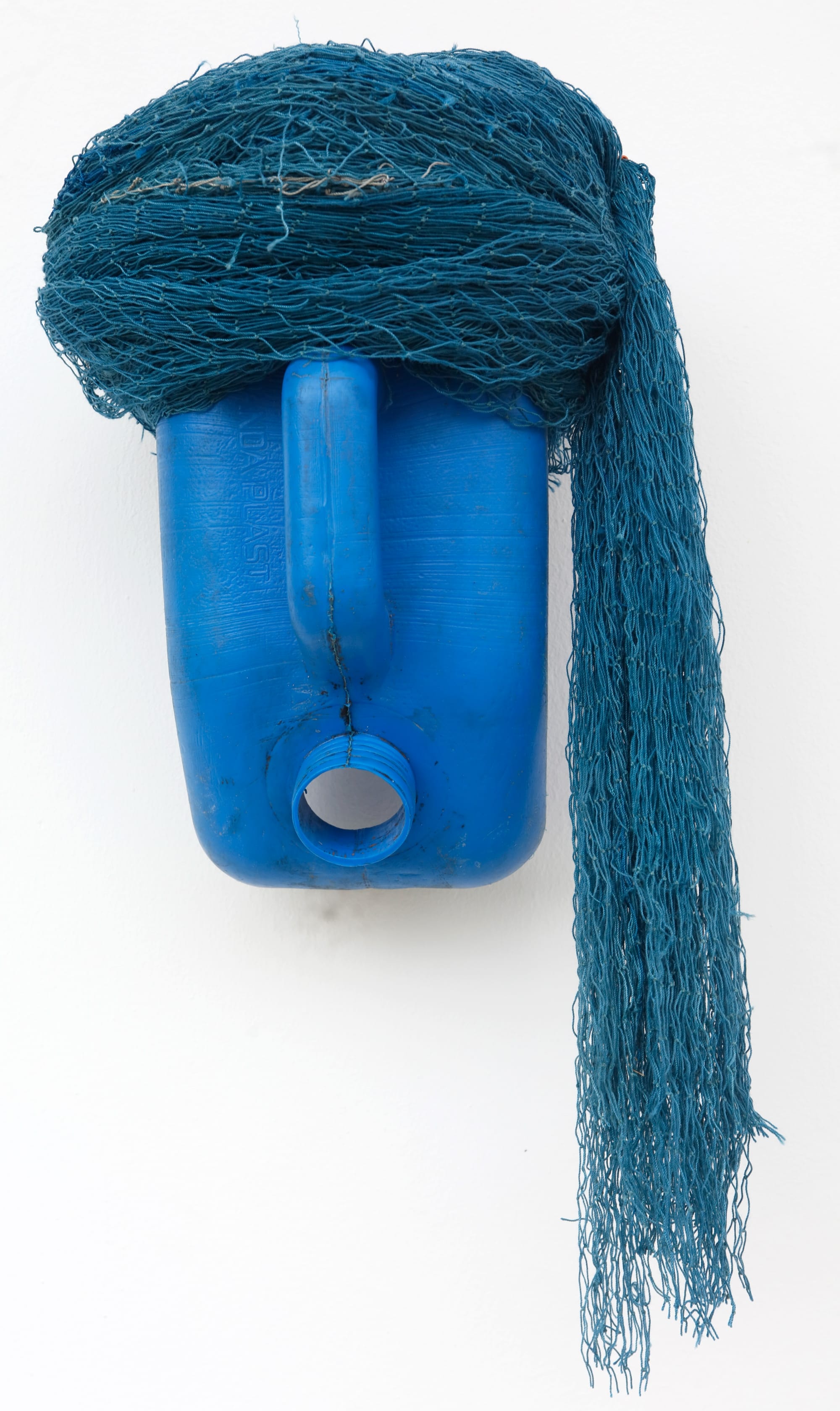 an abstract mask-like sculpture made of a blue plastic jug and blue netting