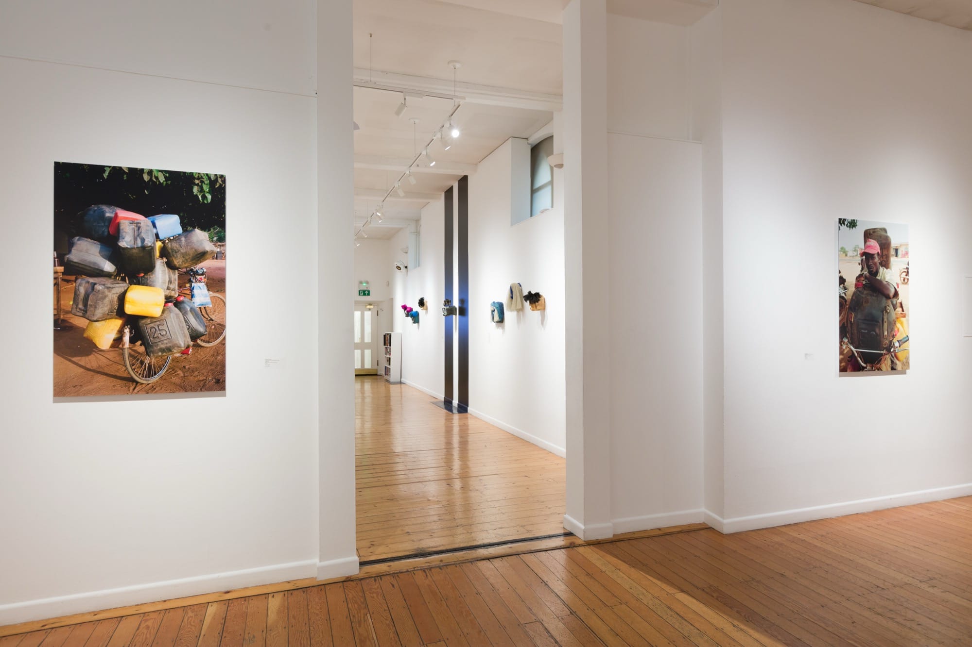 a white walled gallery with photos on a wall