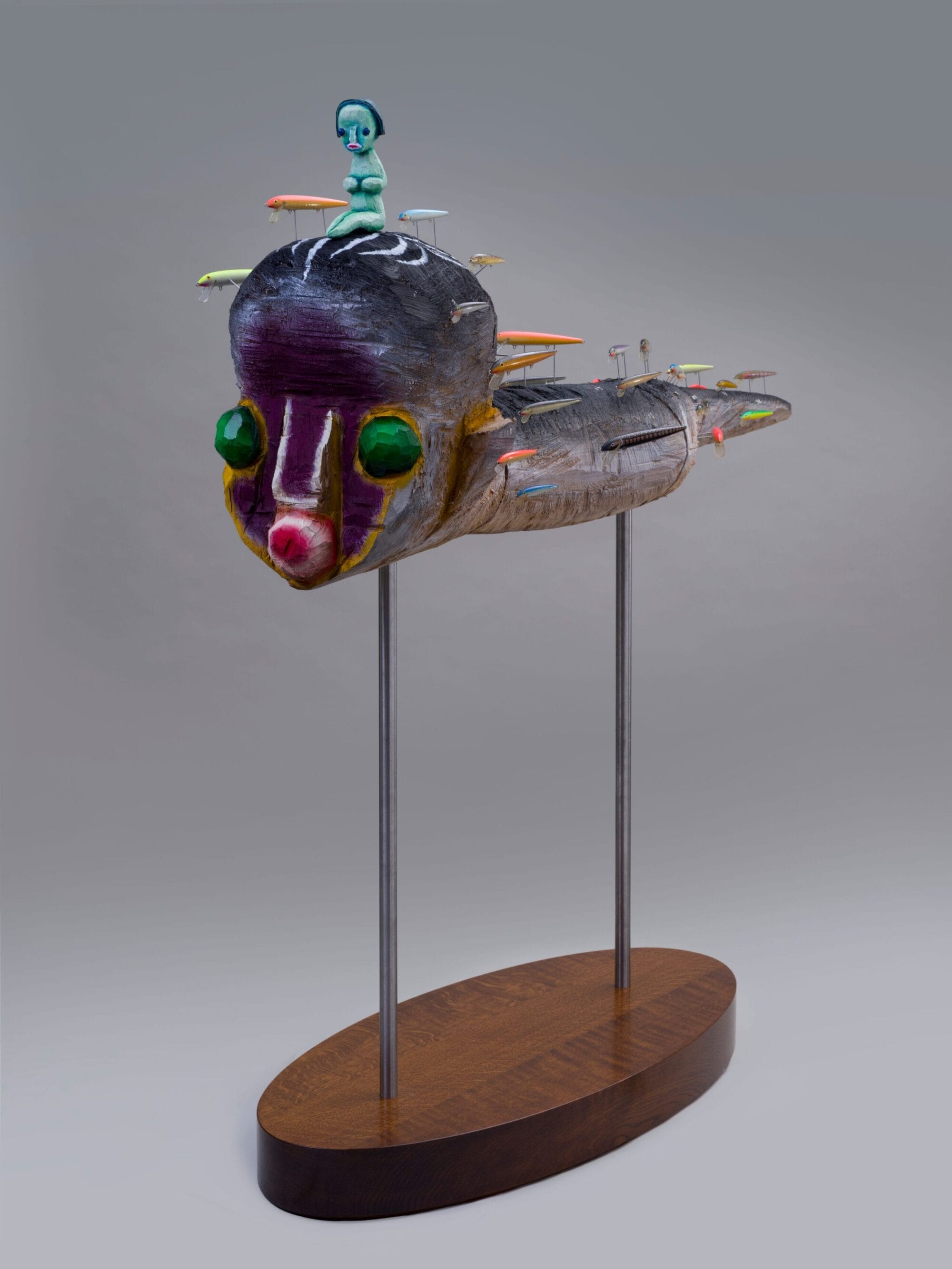 a sculpture by Izumi Kato of a surreal figure seated on top of a another abstracted figure, held up by two metal rods