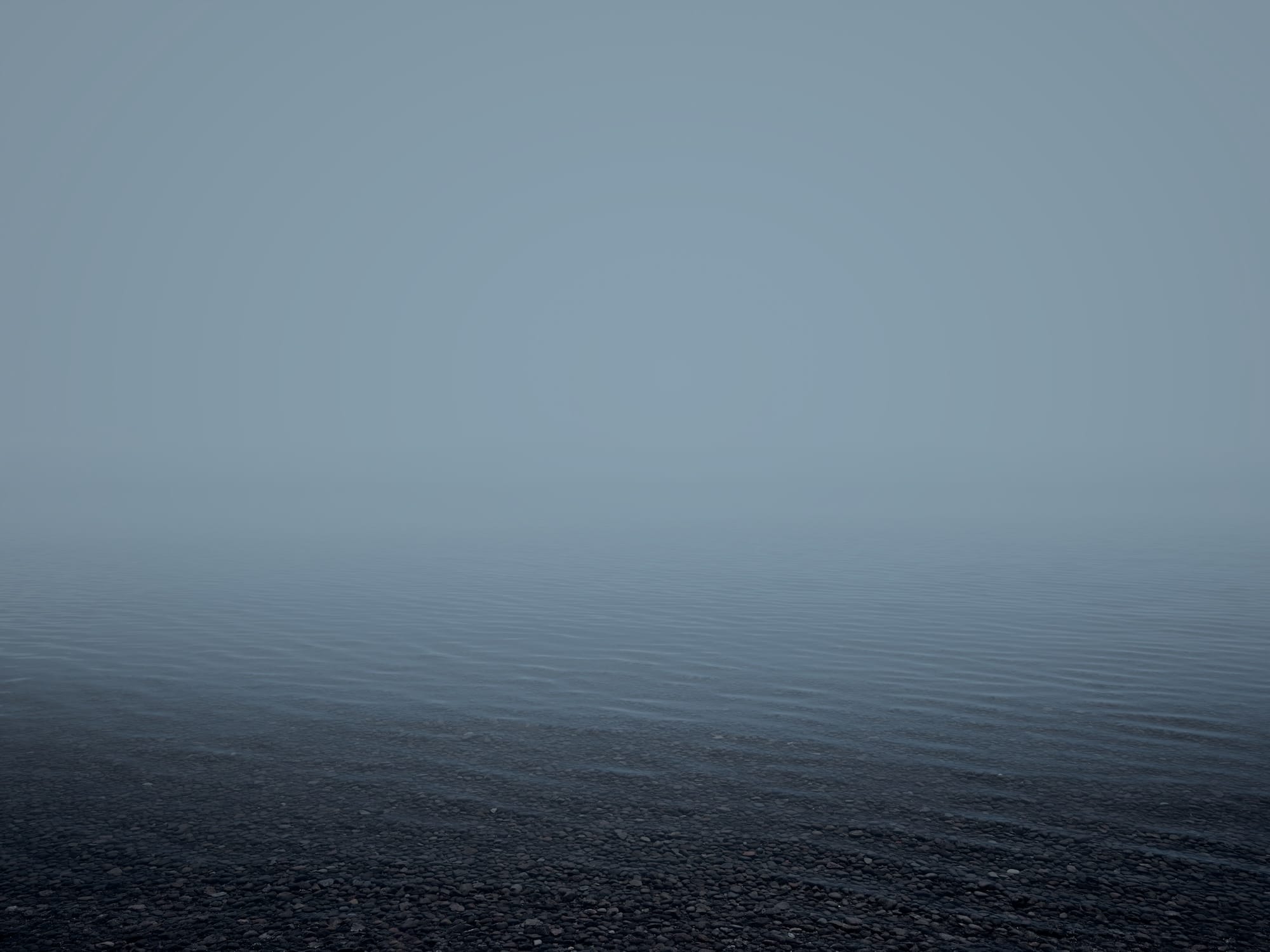 an open body of water on a foggy day