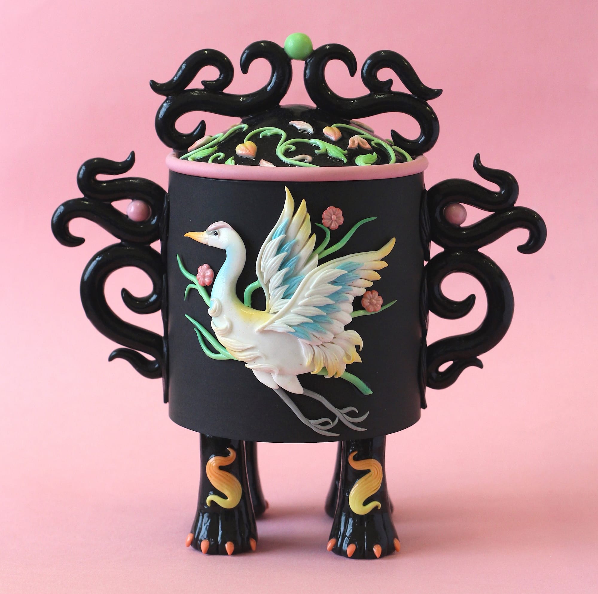a stylized snuff bottle sculpture made from polymer clay featuring a relief of a white crane