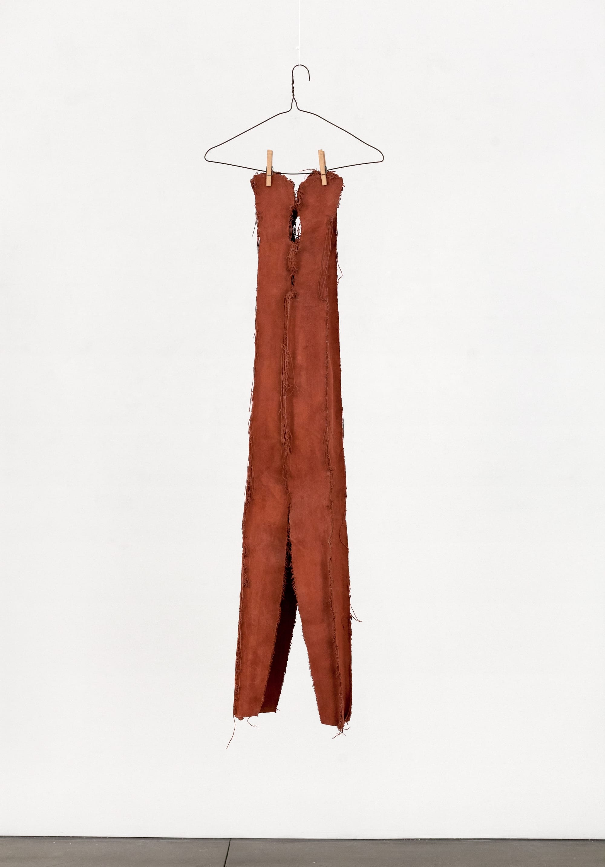 a sculpture of a clothespin made from cloth and draped from a clothes hanger with clothespins