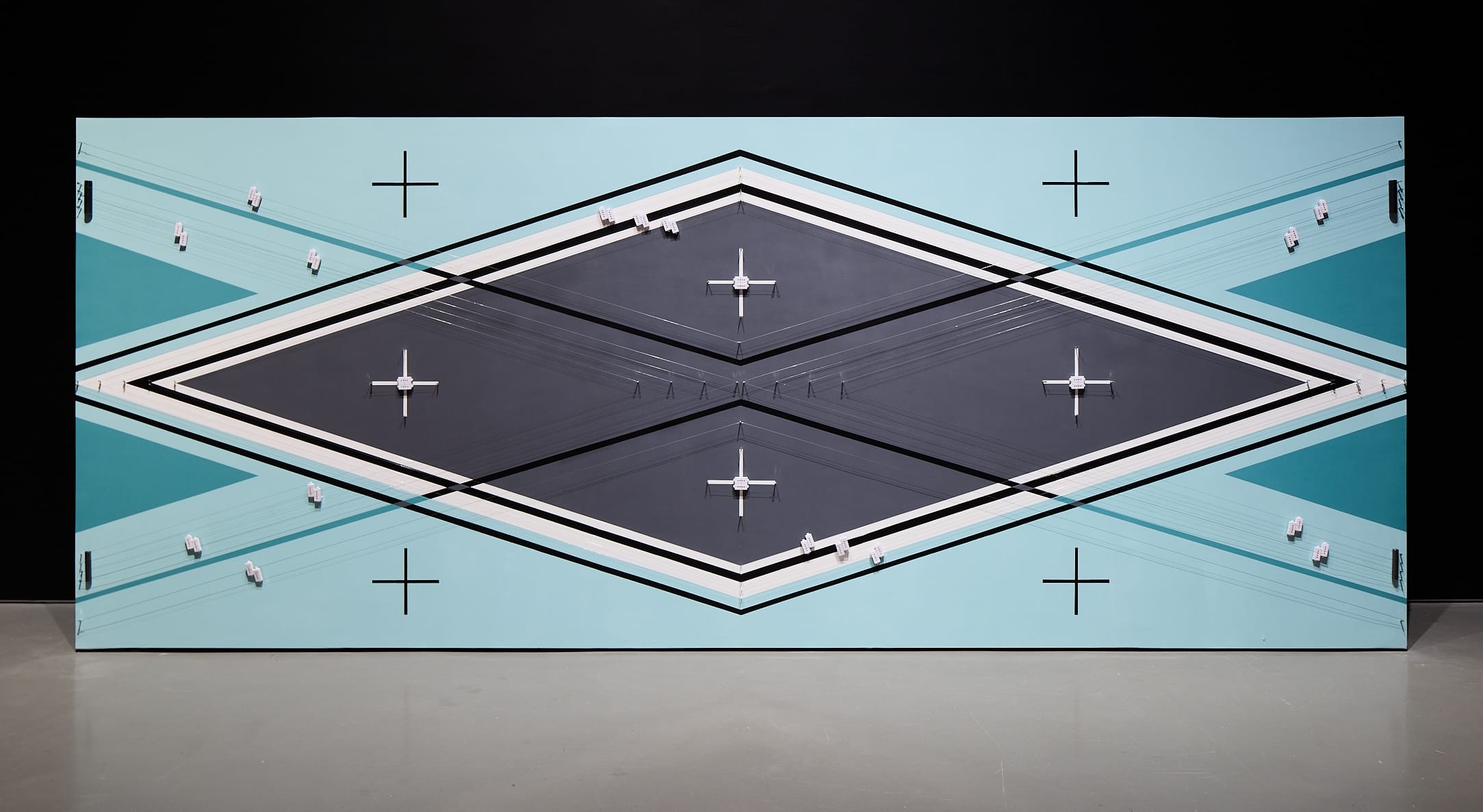 an abstract geometric installation with strings that produce sound on a light blue and black background