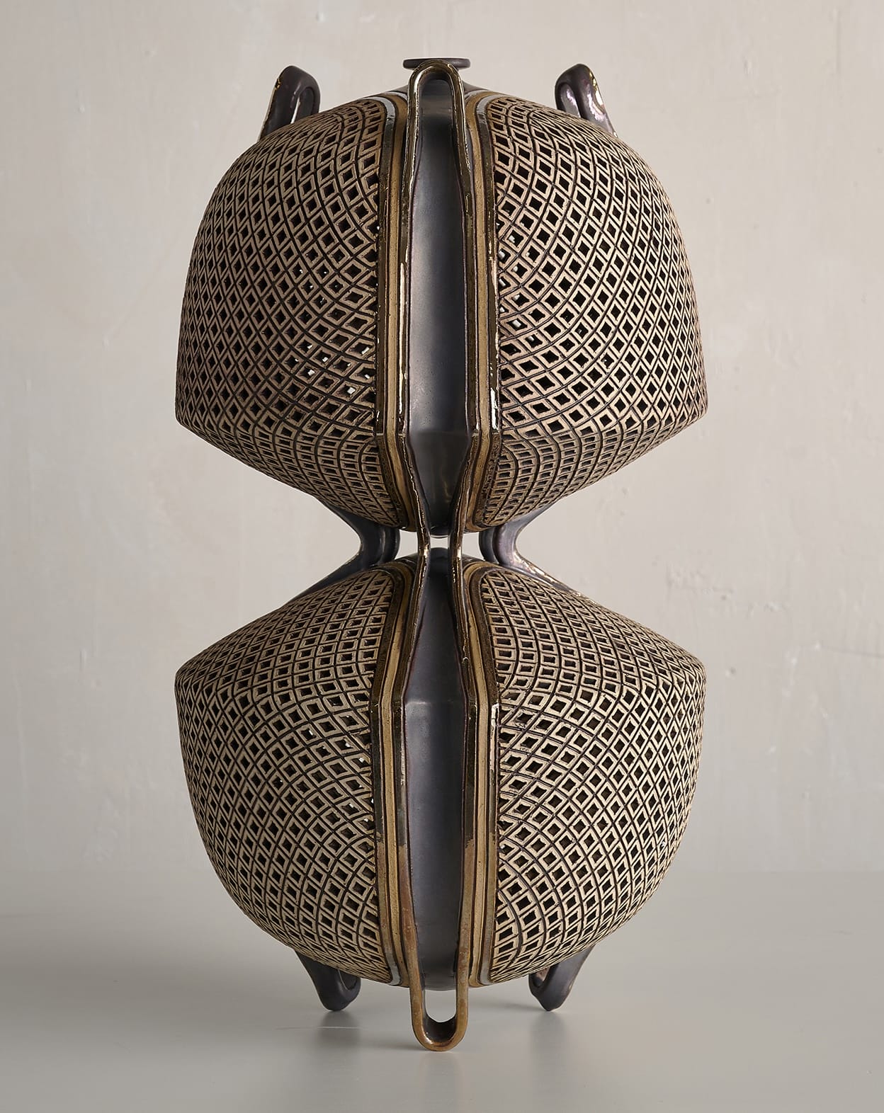 an ornate ceramic sculpture with connected upper and lower vessels