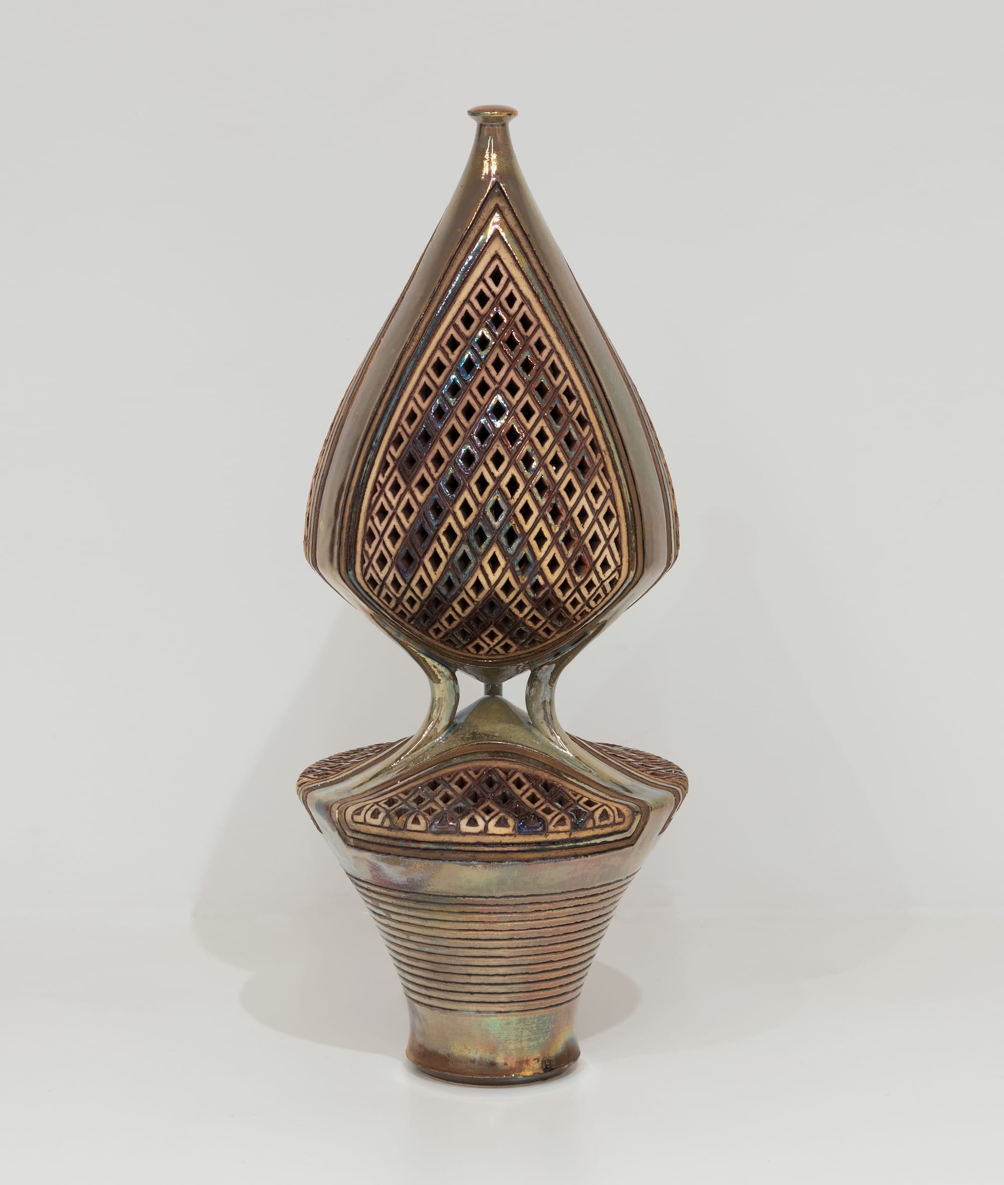 an ornate ceramic sculpture with connected upper and lower vessels