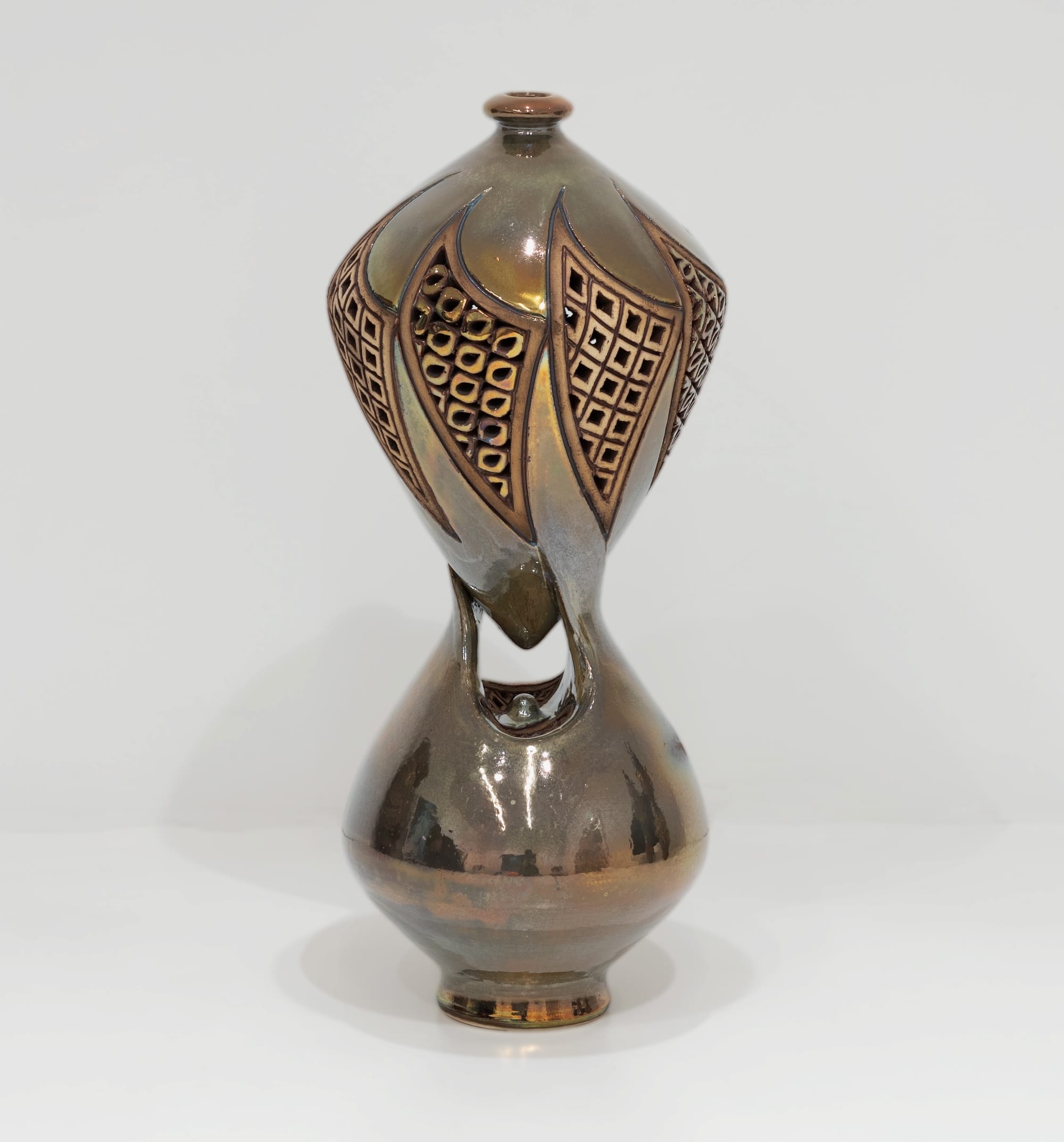 an ornate ceramic sculpture with connected upper and lower vessels