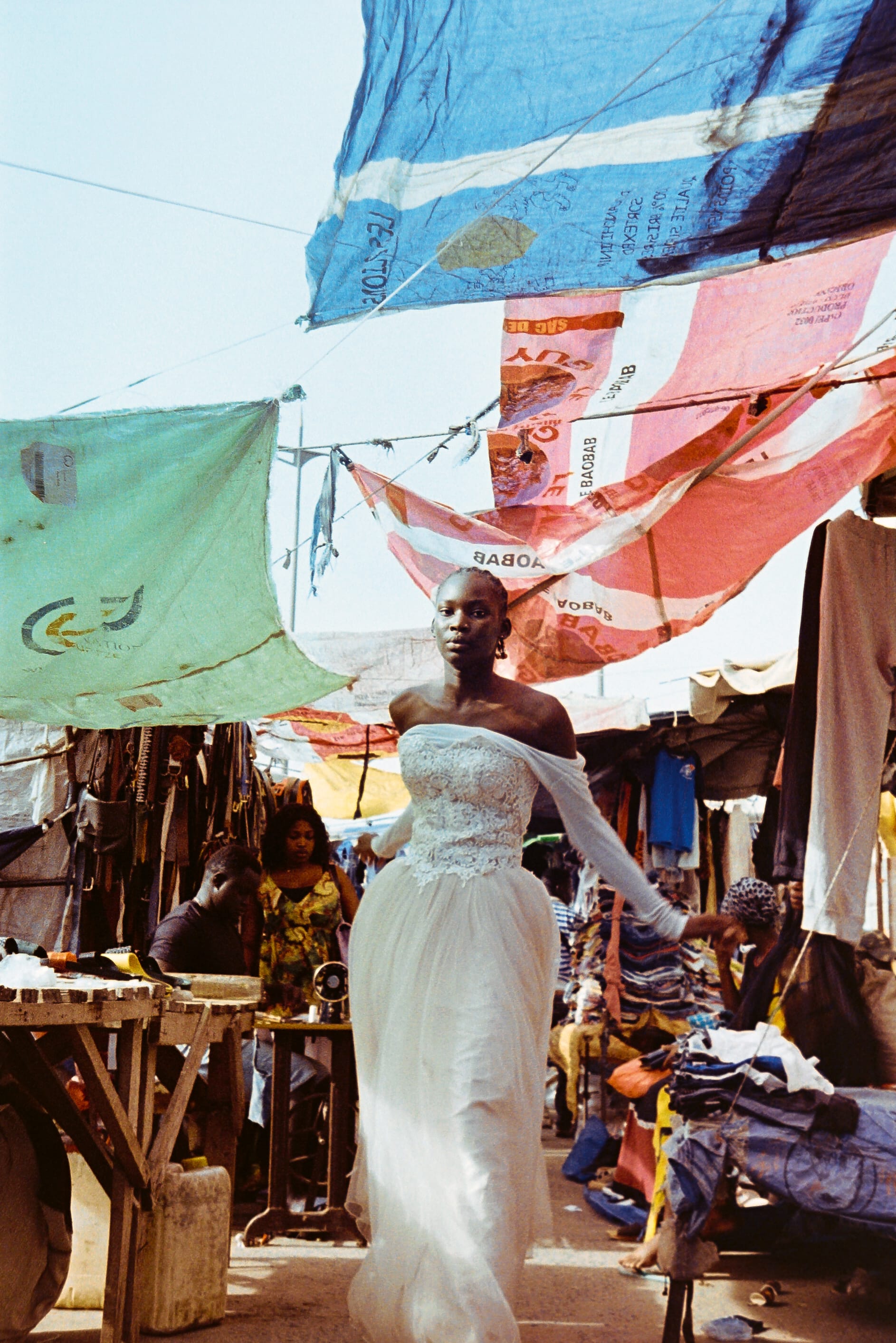 a portrait of a woman in a white dress under colorful canopies